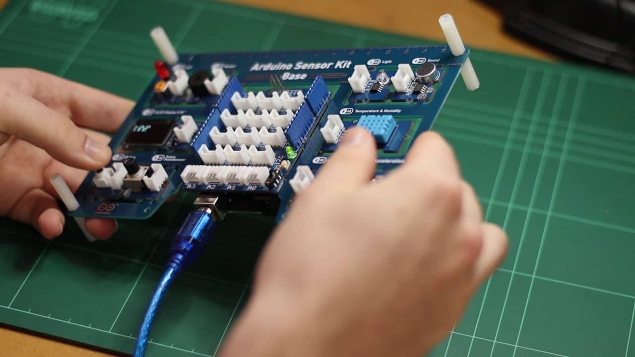 Hands holding the Arduino Base Shield