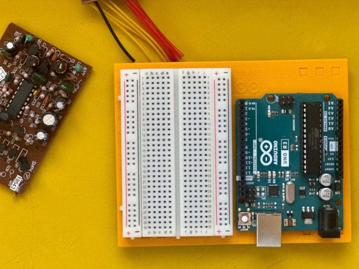 Arduino UNO R3 connected to breadboard on a yellow background