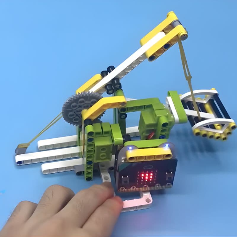 Hands playing with the Ring:bit Bricks Pack trebuchet project