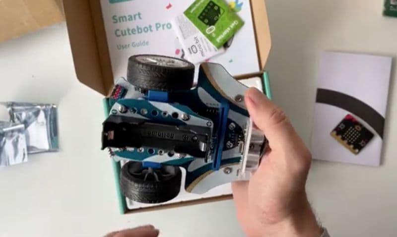 Hand holding the underside of the Cutebot Pro chassis with the box underneath