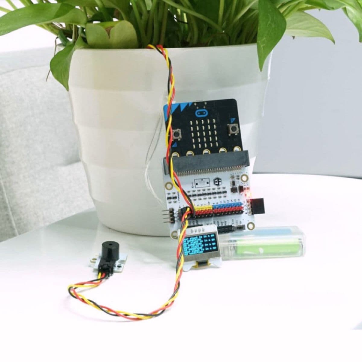 Plant monitoring device built with the Tinker Kit showing moisture sensor in soil