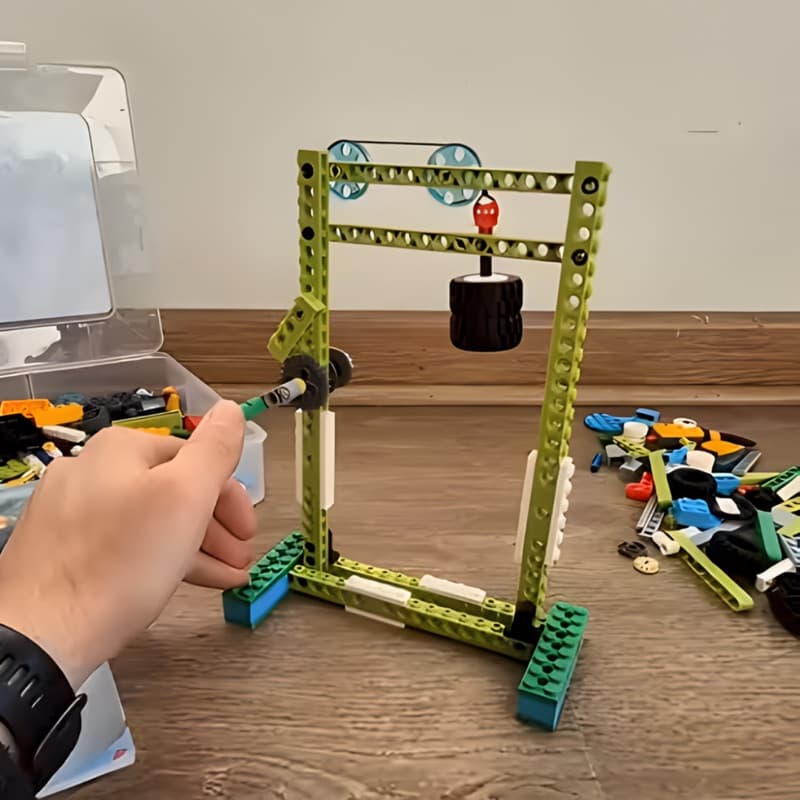 Hand turning a handle mechanism on a Makerzoid build, demonstrating moving parts