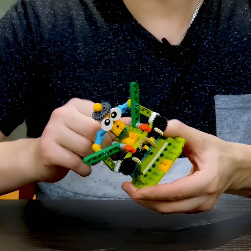 Two hands holding a completed robot build