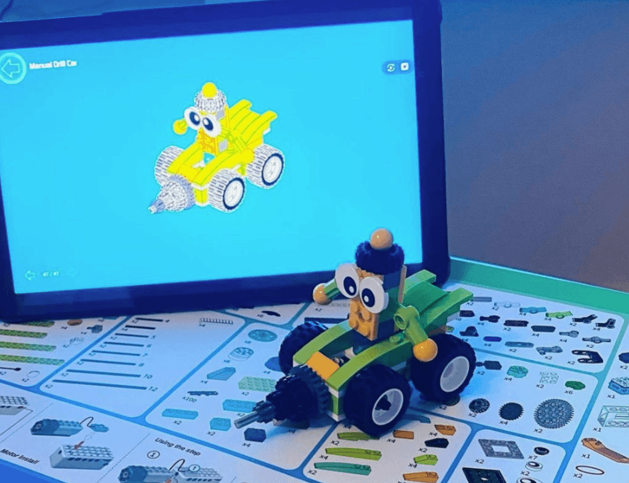 Makerzoid car on box with tablet app open behind