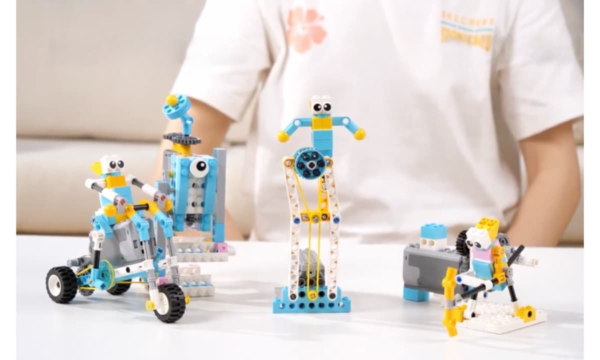Boy surrounded by four completed robot builds he assembled himself