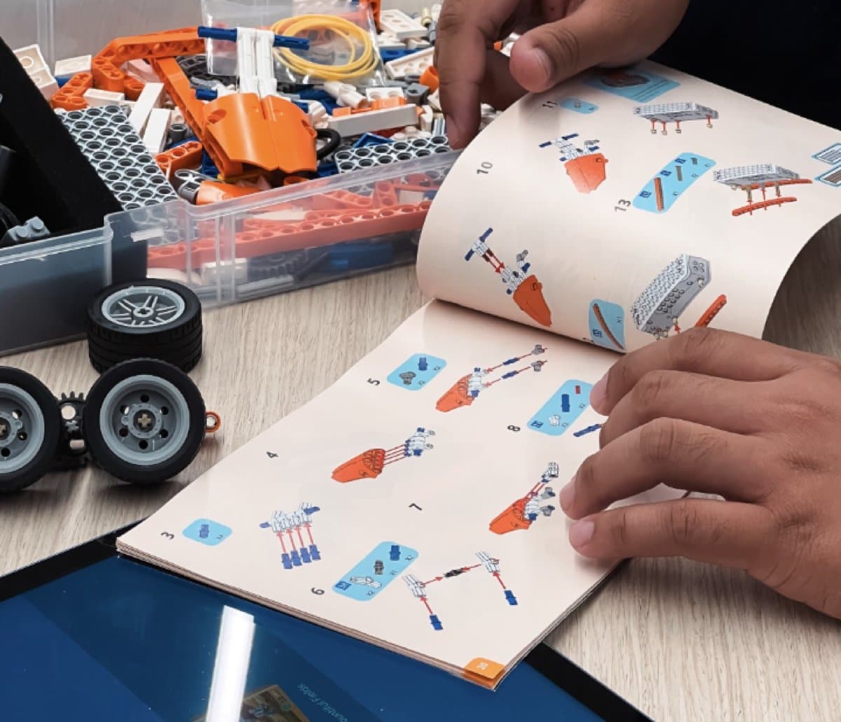 Person flipping through the Makerzoid Superbot booklet build instructions