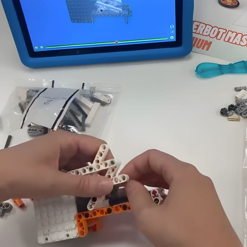 Hands assembling the Superbot with step-by-step instructions on a tablet