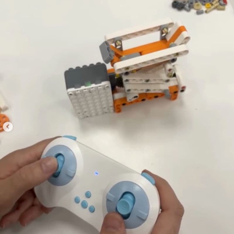 Child using the Bluetooth remote to control an assembled Superbot robot