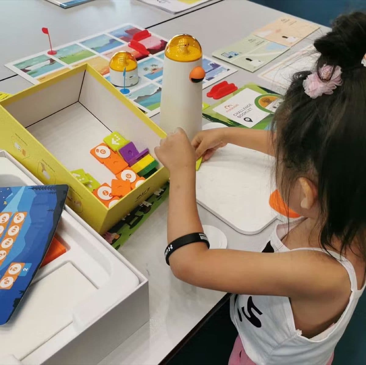Girl independently placing coding blocks on the control board