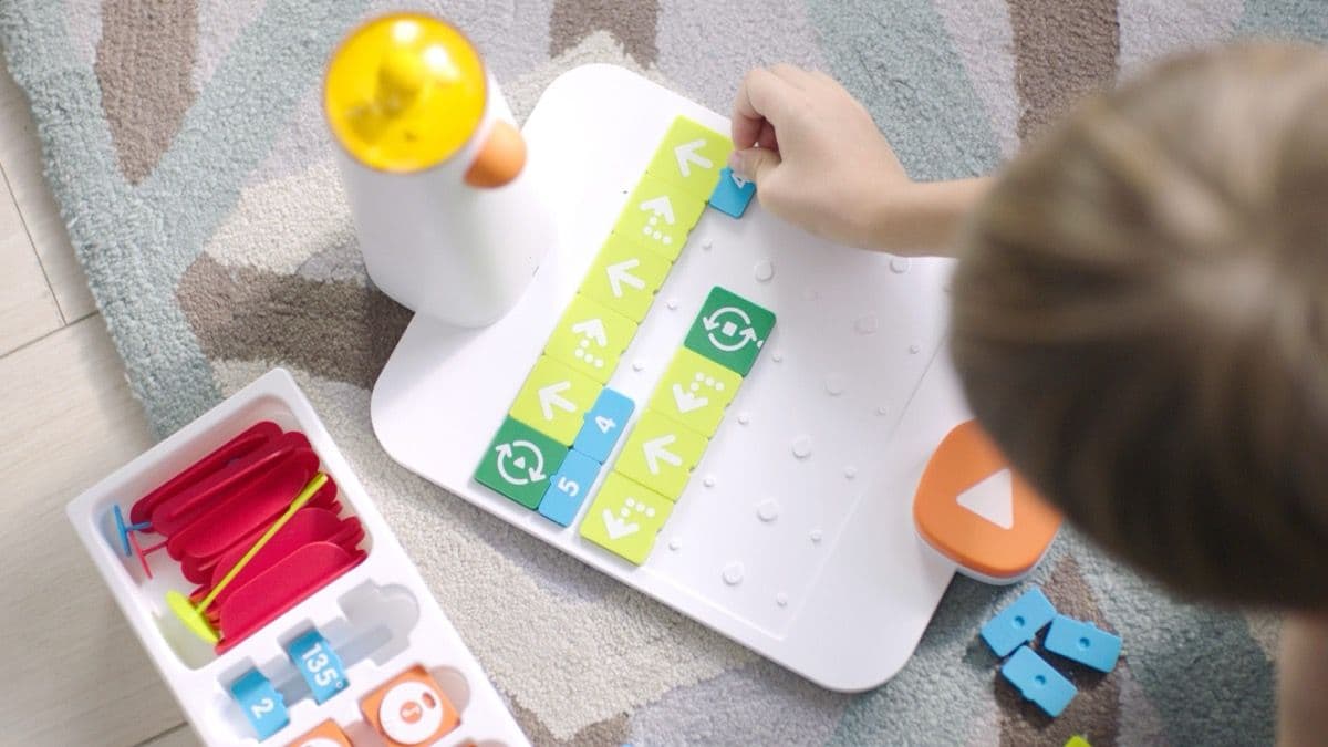 Top-down view of a child carefully placing coding blocks in sequence