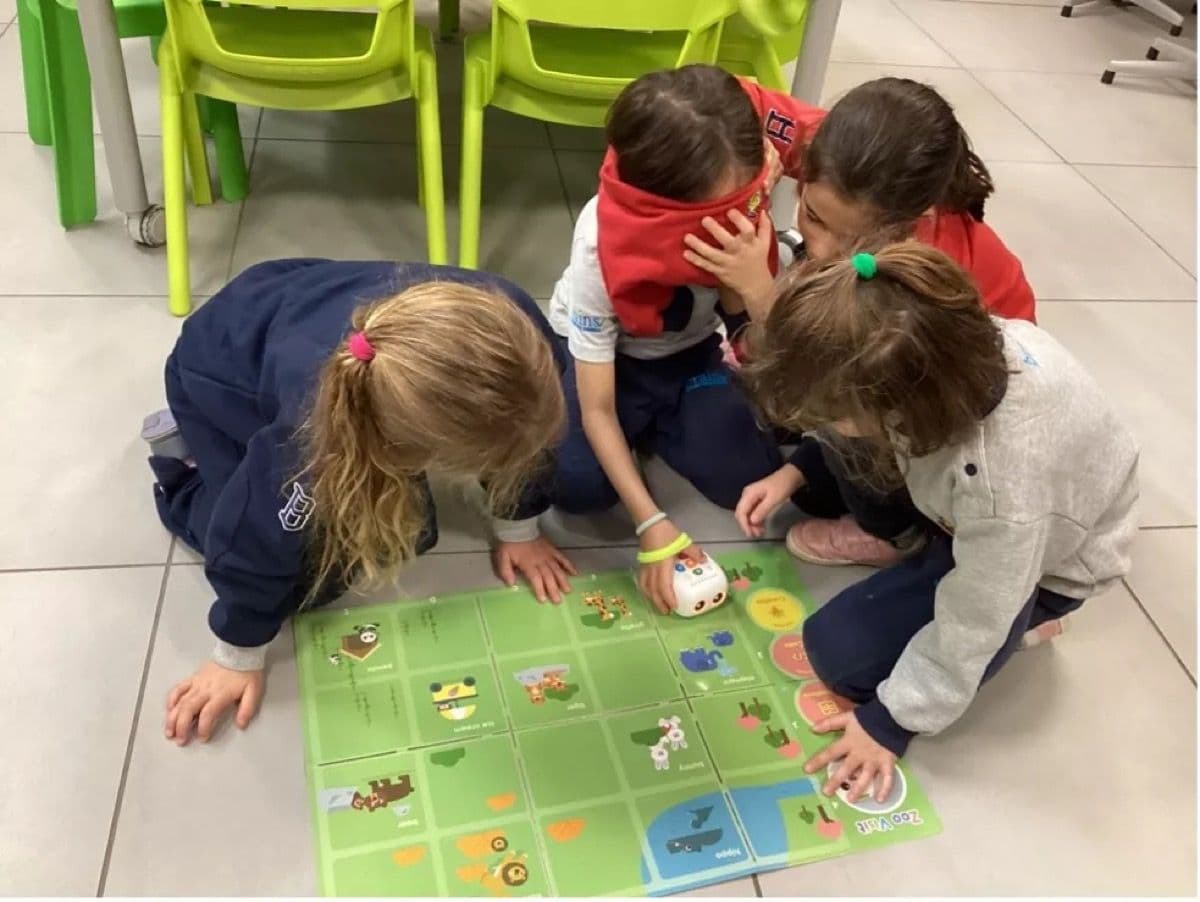Children sitting on the floor working with Tale-Bot Pro on interactive maps