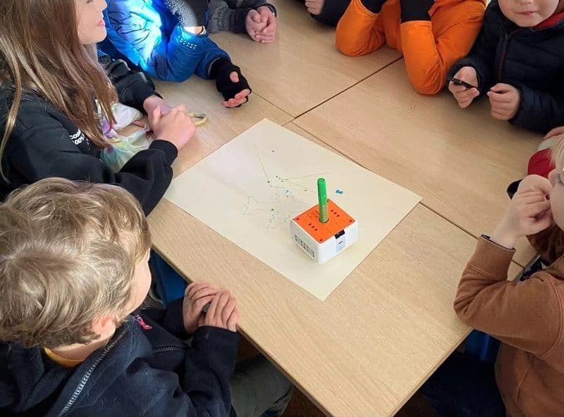 Kids watching VinciBot draw with a marker