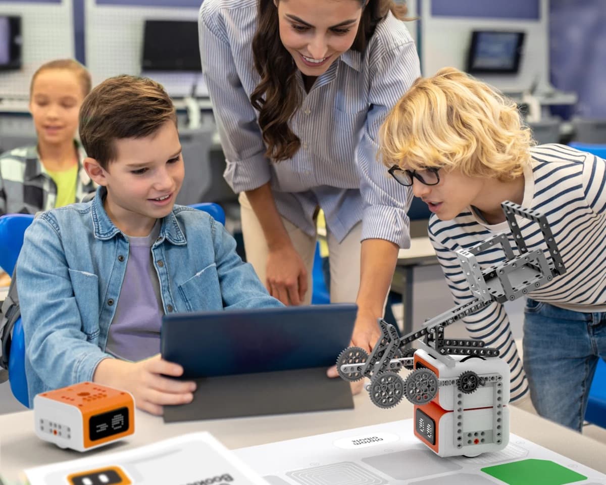 Kids and teacher working with VinciBot through a tablet interface