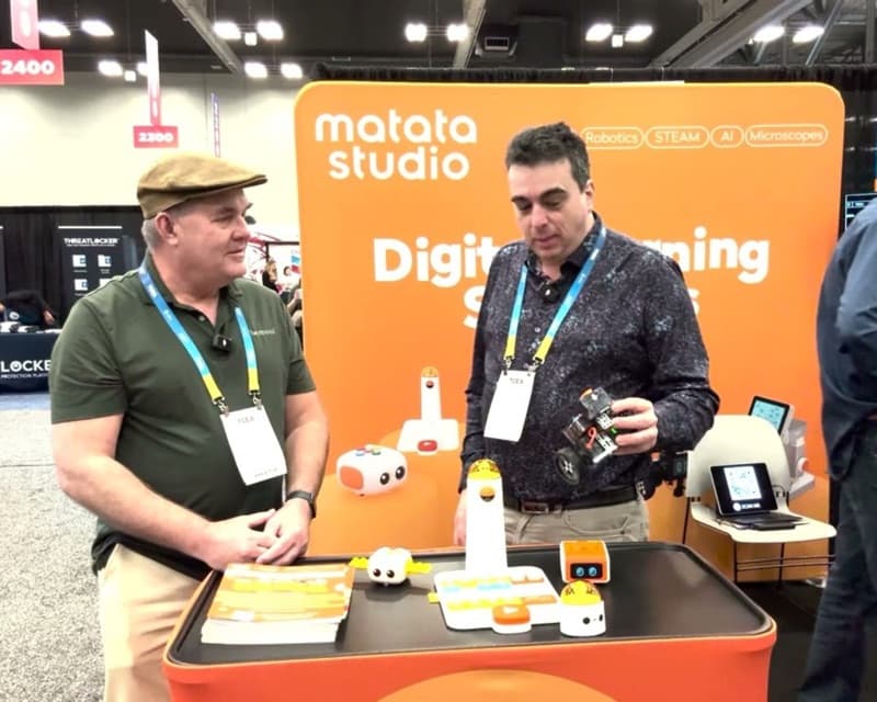 Educators discussing MatataStudio at a conference booth