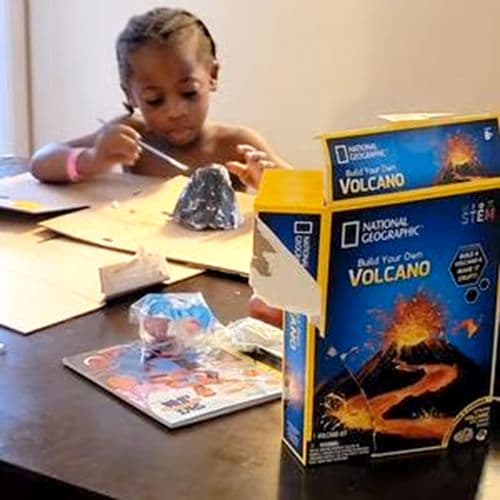 Child painting their volcano with the kit box in front