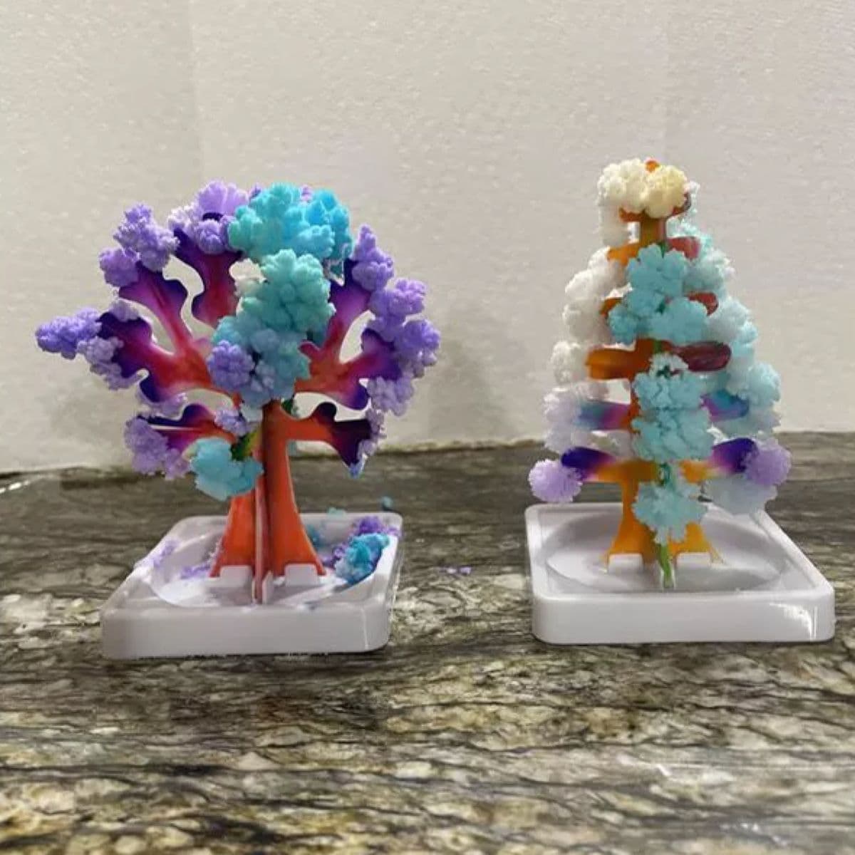 Two crystal trees covered in growing crystals in their chosen colours