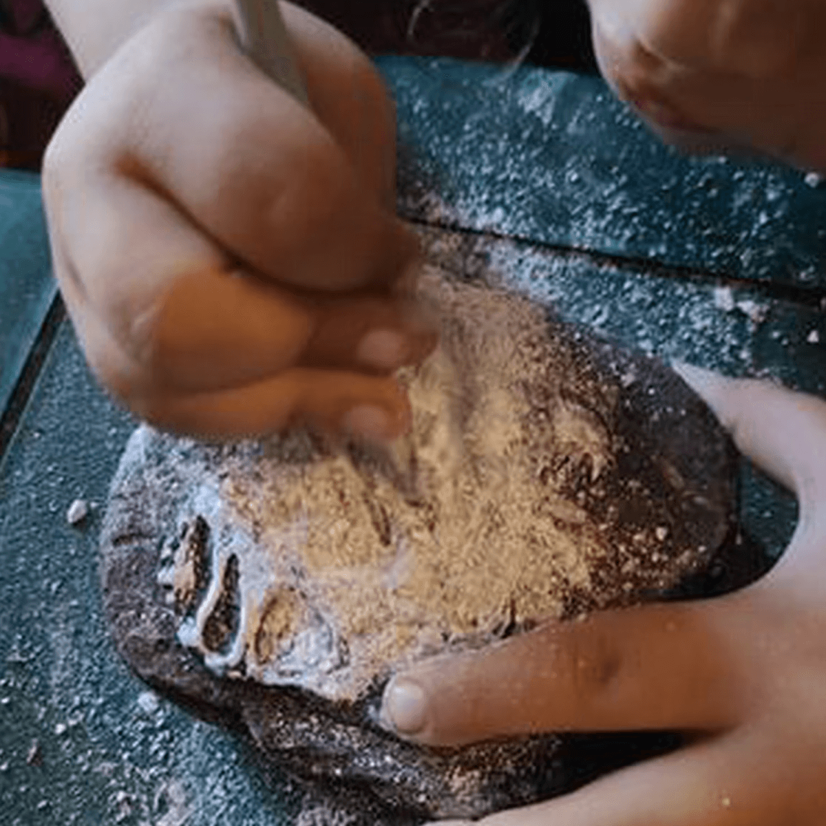 Kids carefully scraping at a fossil dig brick