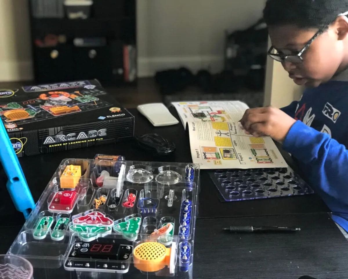 Child reading the Snap Circuits Arcade full-colour instruction manual