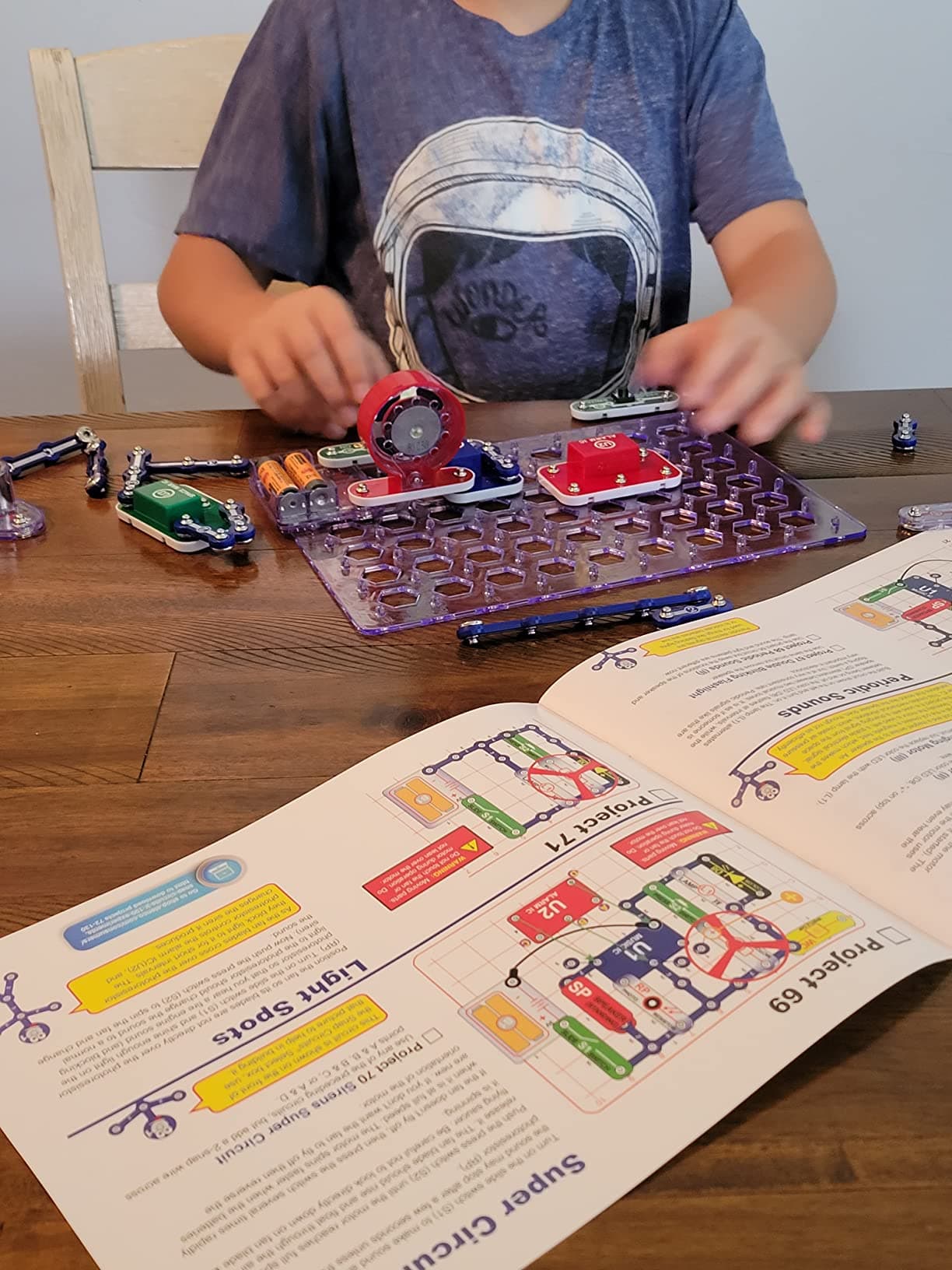 Child following manual while building Snap Circuits project